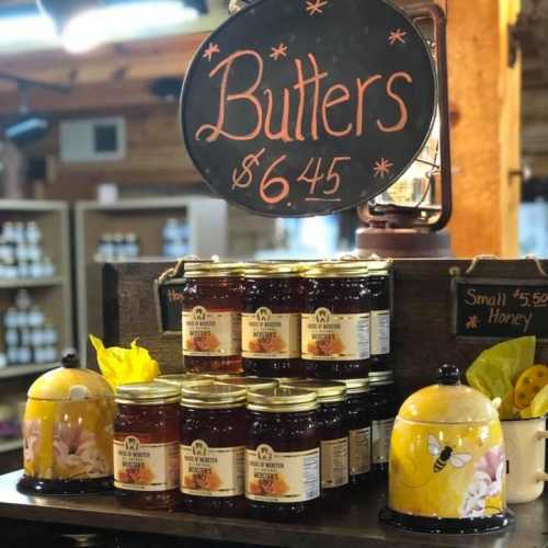 Display of various jars of butters and honey, with a sign indicating the price of butters at $6.45.