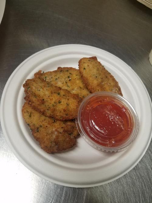 A white plate with four golden-brown breaded fish fillets and a small cup of red dipping sauce.