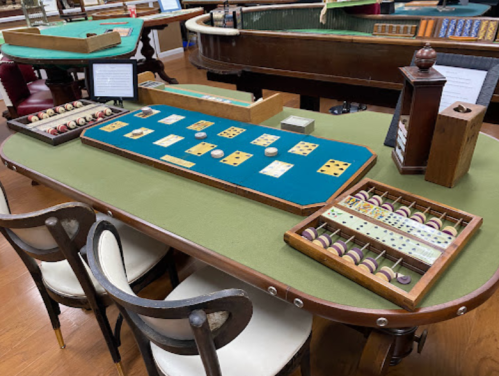A vintage gaming table with various betting chips and game pieces displayed in a museum setting.