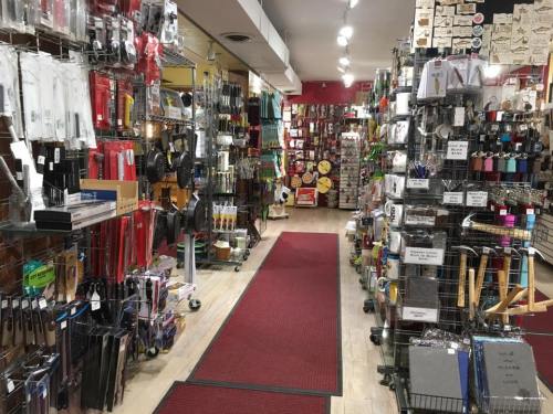 A colorful aisle in a store filled with various kitchen tools and supplies, with shelves on both sides.
