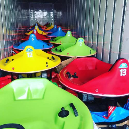 A row of colorful go-kart seats in a storage container, featuring red, green, yellow, and blue colors.