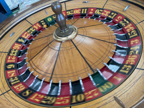 A close-up of a spinning roulette wheel with red and black numbered pockets.