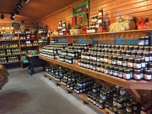 A cozy store interior filled with shelves of jars, showcasing various spreads and preserves, decorated with autumn accents.