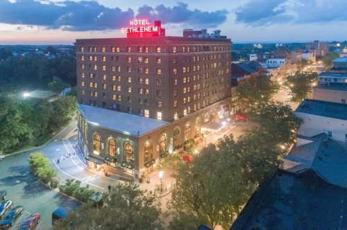 Aerial view of Hotel Bethlehem at dusk, with its illuminated sign and surrounding cityscape.