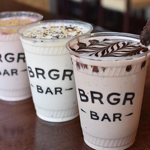 Three milkshakes in clear cups with "BRGR BAR" printed on them, featuring different flavors and toppings.