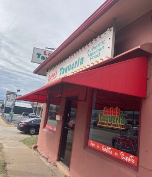 Exterior of Lalo's Taqueria, featuring a red awning and signs for authentic Mexican food, with an "OPEN" sign visible.