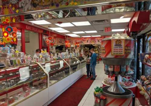 A colorful candy shop interior with glass displays, bright lights, and customers browsing sweets.