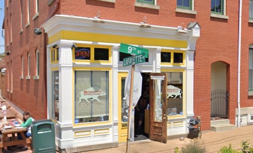 A colorful storefront with a yellow facade, featuring "Bogart's Smoke House" signage and an open sign.