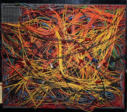A chaotic arrangement of colorful wires and cables intertwined on a circuit board.