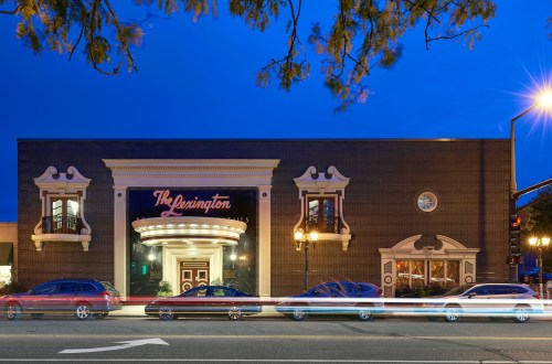 The Lexington building at dusk, featuring elegant architecture and light trails from passing cars.