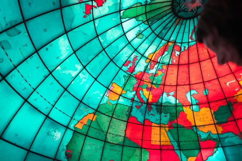 A colorful globe viewed from below, highlighting continents and oceans with vibrant colors.
