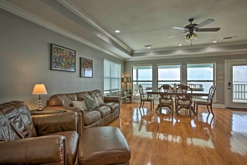 Cozy living area with leather furniture, dining table, and large windows offering a view of the outdoors.