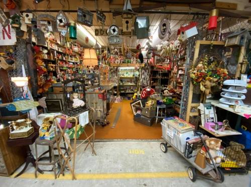 A cluttered antique shop entrance filled with various vintage items, decor, and collectibles.