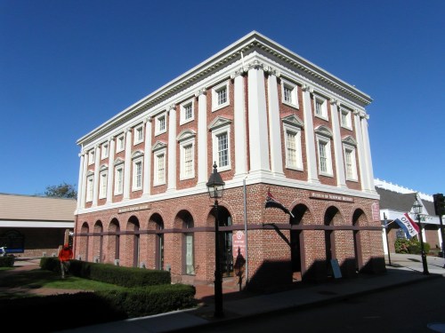 Historic brick building with white columns, featuring arched windows and a sign for the Museum of Newport History.