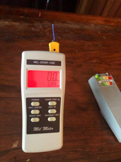 A MEL-8704R-VIBE meter displaying a reading of 0.00 and a secondary device with a color-coded indicator.
