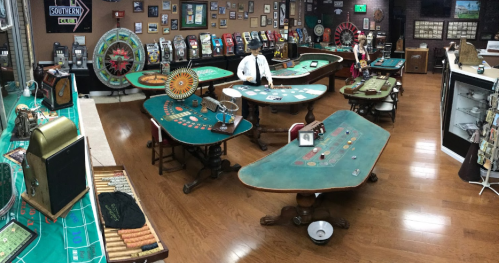 A vintage casino room with gaming tables, slot machines, and decor, showcasing a nostalgic gambling atmosphere.