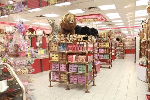 A colorful store interior filled with stuffed animals and decorative items on shelves, featuring a large lion statue.