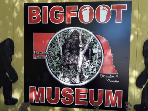 Sign for the Bigfoot Museum in Hastings, Nebraska, featuring a Bigfoot illustration and footprints.