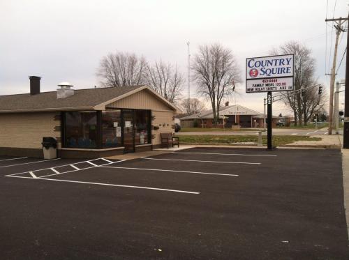 A small restaurant building with a sign reading "Country Squire" and empty parking spaces in front.