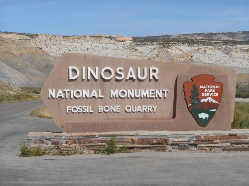 Sign for Dinosaur National Monument, featuring "Fossil Bone Quarry" and the National Park Service logo.