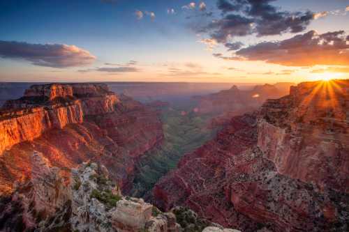 A stunning sunset over the Grand Canyon, highlighting the layered rock formations and vibrant colors of the landscape.