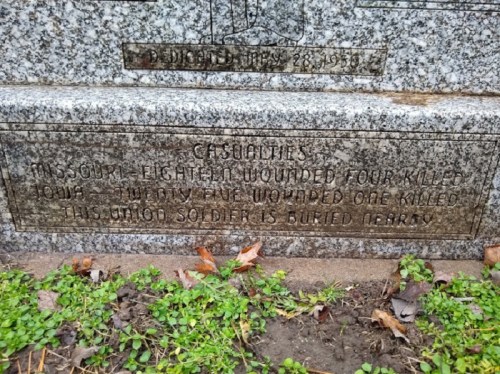 Gravestone inscription detailing casualties: 18 wounded, 4 killed, and mentions a soldier buried nearby.