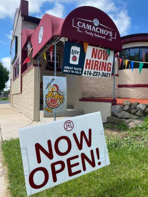 Signage outside Camacho's Family Restaurant announcing "Now Hiring" and "Now Open," with a phone number displayed.