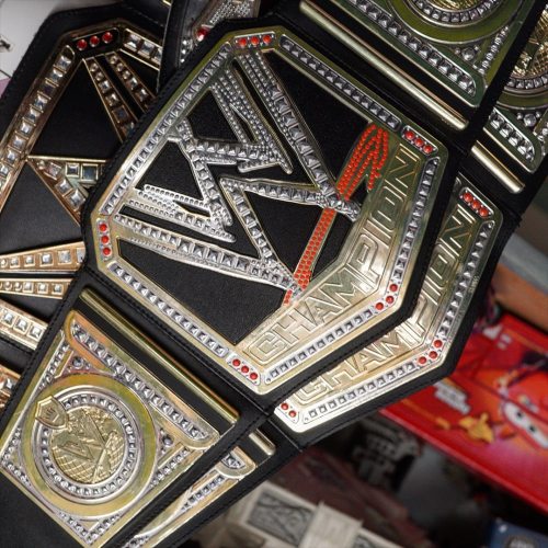 Close-up of a WWE championship belt featuring intricate designs and sparkling embellishments.