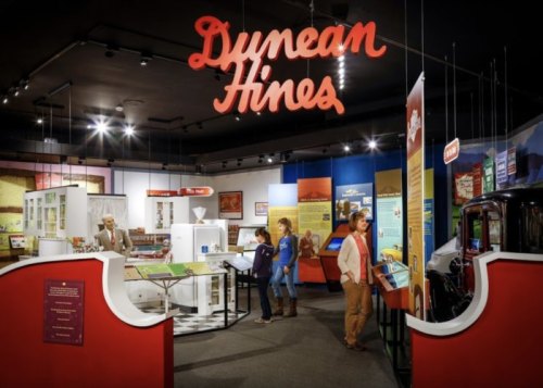 Exhibit showcasing Dunean Hines with displays, artifacts, and visitors exploring the museum space.