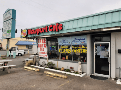 Exterior of Newport Cafe with a sign for takeout and delivery, featuring seafood offerings and a casual atmosphere.
