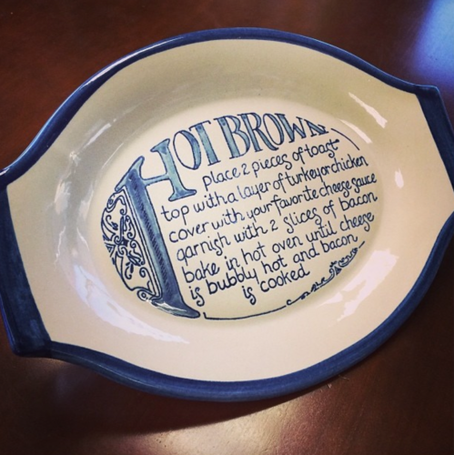 A decorative dish with a recipe for Hot Brown, featuring instructions and a blue design around the edge.