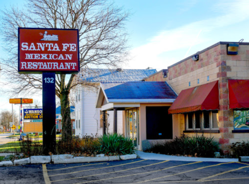 Exterior of Santa Fe Mexican Restaurant, featuring a large sign and a brick building with a red awning.