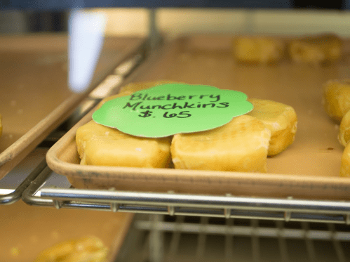 A tray of blueberry munchkins with a green label displaying the price of $0.65.