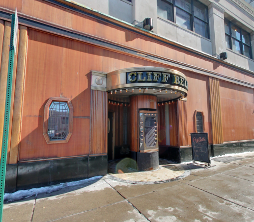 Art Deco-style entrance of Cliff Bell's restaurant, featuring a marquee and a sign, with snow on the ground.