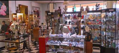 A vintage shop filled with various antiques, collectibles, and decorative items displayed in glass cases.