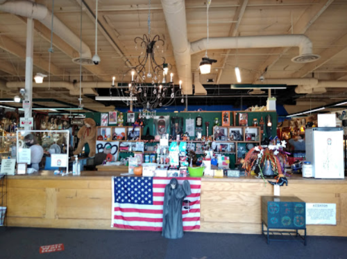 A vibrant store interior featuring a wooden counter, American flag, and various colorful items on display.