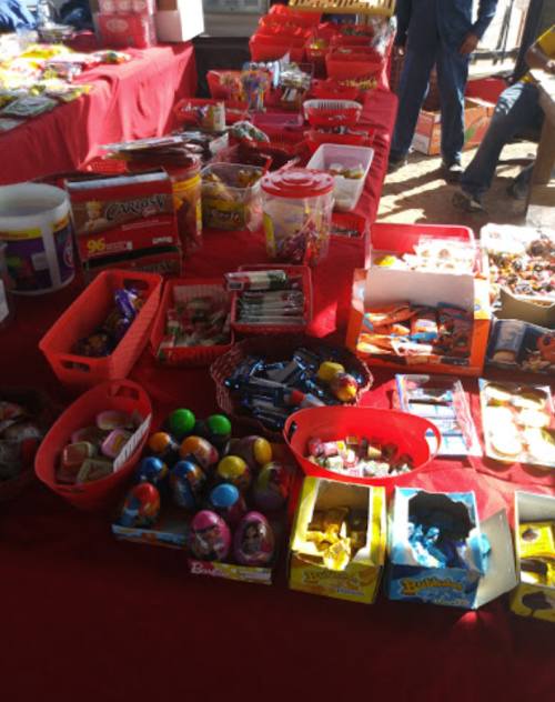 A colorful display of various candies and snacks arranged in red baskets on a table.