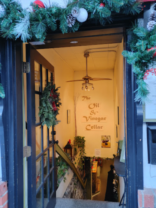Entrance to "The Oil & Vinegar Cellar," featuring a decorated doorway and stairs leading down to the shop.