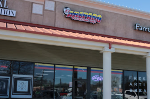 Storefront of a business with a colorful sign reading "El Paso" and an "Open" sign, featuring a modern design.