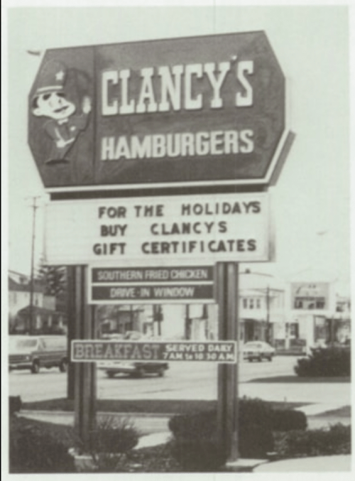 Black and white photo of Clancy's Hamburgers sign promoting holiday gift certificates and breakfast hours.