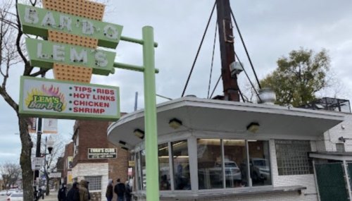 A retro-style barbecue restaurant sign with menu items like tips, ribs, hot links, chicken, and shrimp.