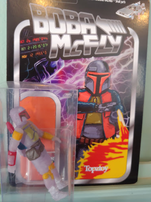 A toy figure of Boba McFly in packaging, featuring a colorful design and a sci-fi background.