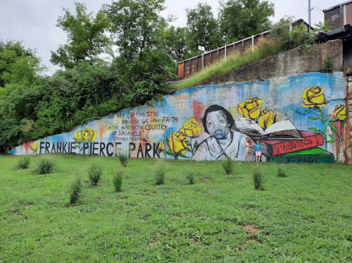 Colorful mural at Frankie Pierce Park featuring a woman's portrait and yellow roses, celebrating optimism and faith.