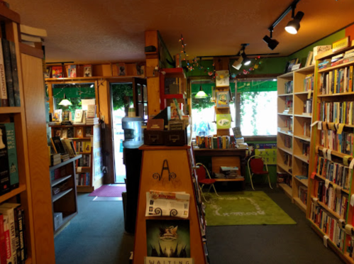 Cozy bookstore interior with bookshelves, a checkout counter, and colorful decor, inviting readers to explore.
