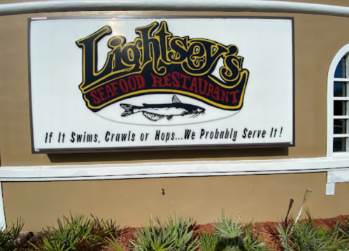 Sign for Lightsey's Seafood Restaurant featuring a fish graphic and the slogan, "If it Swims, Crawls or Hops... We Probably Serve It!"