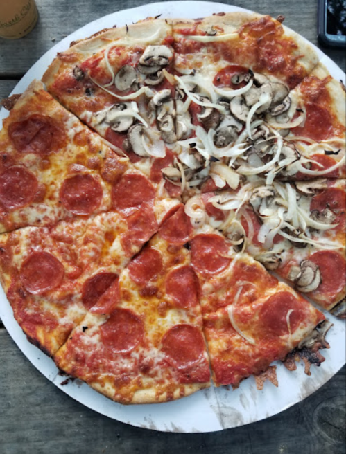 A pizza divided into two halves: one with pepperoni and the other topped with mushrooms and onions.