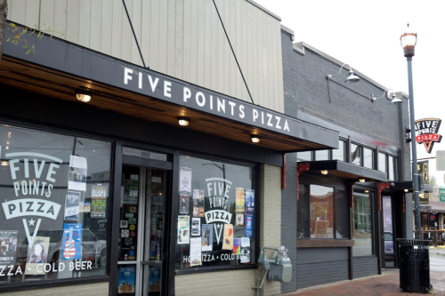 Exterior of Five Points Pizza, featuring a sign and large windows displaying the restaurant's name and menu.