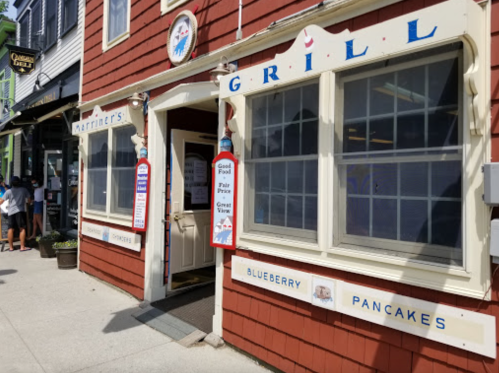 Exterior of Mariners Grill, featuring a red wooden facade, windows with signs for blueberry pancakes and good food.