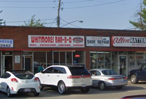 A storefront featuring "Whitmore's Bar-B-Q" and "Allen Shoe Repair," with parked cars in front.
