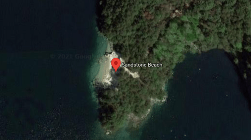 Aerial view of Sandstone Beach, surrounded by water and greenery.